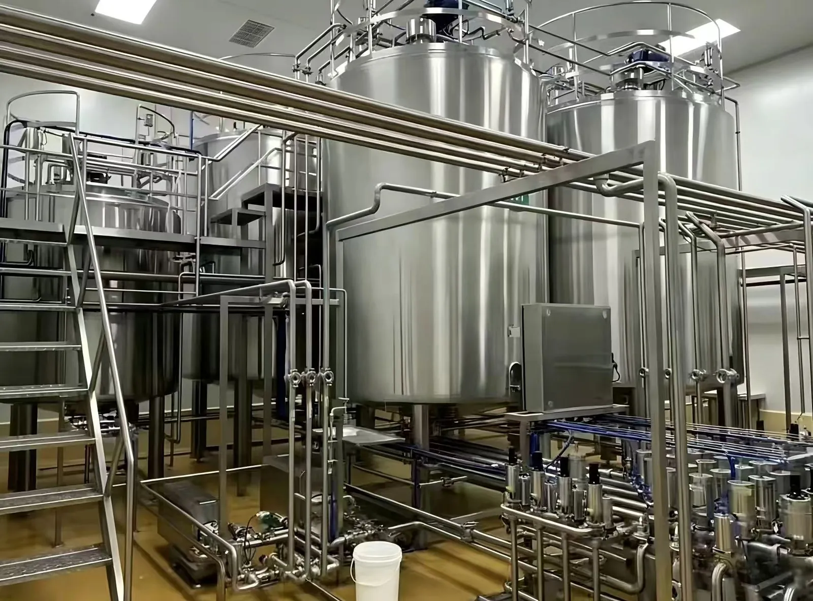 Tanques de proceso encamisados, plataforma y matriz de válvulas en una sala de producción